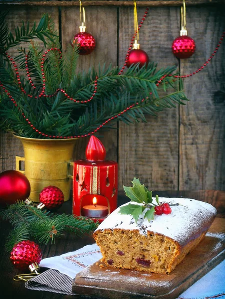 Gâteau traditionnel aux fruits de Noël décoré de sucre en poudre et décorations de Noël, bougie. espace de copie. style rustique. focus sélectif — Photo