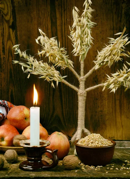 Ukrayna Noel kavramı tebrik kartı için. Xmas sembolü didukh, mum, elma, ceviz, buğday ahşap arka plan üzerinde yanan bileşimi. Uzay kopyalayın. Seçici odak