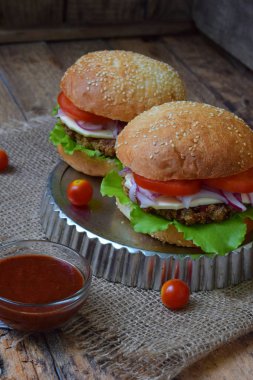 patlıcan, marul, soğan turşusu, domates kahverengi ahşap arka plan üzerinde bir chop sebze Burger.