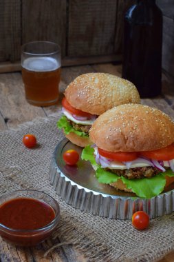 patlıcan, marul, soğan turşusu, domates kahverengi ahşap arka plan üzerinde bir chop sebze Burger.