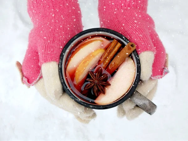 Female hands holding mug of mulled wine with apple and spices. Cup of seasonal hot drink. Homemade fruit tea. — Stock Photo, Image