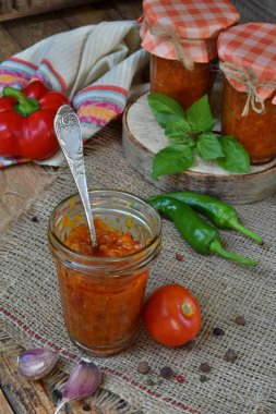 Biber, biber ve sarımsak ile domates sosu kavanoz. Bolognese sos, lecho veya adjika. Koruma. Canning