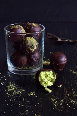 Hindistan cevizi, avokado ve çay matcha ile sağlıklı ham enerji ısırıkları. Vegan çikolata truffles koyu ahşap zemin üzerinde. Ev yapımı şeker. Kopya alanı
