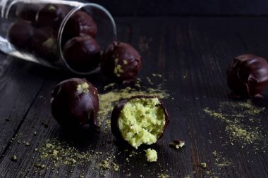 Hindistan cevizi, avokado ve çay matcha ile sağlıklı ham enerji ısırıkları. Vegan çikolata truffles koyu ahşap zemin üzerinde. Ev yapımı şeker. Kopya alanı