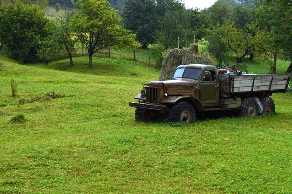 Camión gris muy viejo sin marca registrada en la hierba verde —  Fotos de Stock