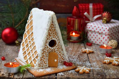 Çamın dalları, koniler ile bisküvi koyu arka plan üzerinde ev yapımı kurabiye evi. Avrupa Noel gelenekleri. Xmas tatil tatlılar.