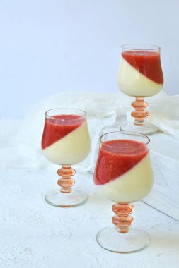 Geleneksel İtalyan tatlı panna cotta berry jello ile cam. Açık renkli vanilyalı süt çilekli tatlı katmanlı.