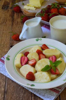 Tatlı berry kahvaltı. Tatlı tembel pierogi, ekşi krema, tereyağı ve çilek ahşap arka plan üzerinde köfte. İtalyan gnocchi. Metniniz için kopya alanı
