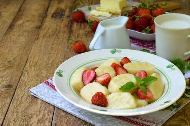Tatlı berry kahvaltı. Tatlı tembel pierogi, ekşi krema, tereyağı ve çilek ahşap arka plan üzerinde köfte. İtalyan gnocchi. Metniniz için kopya alanı