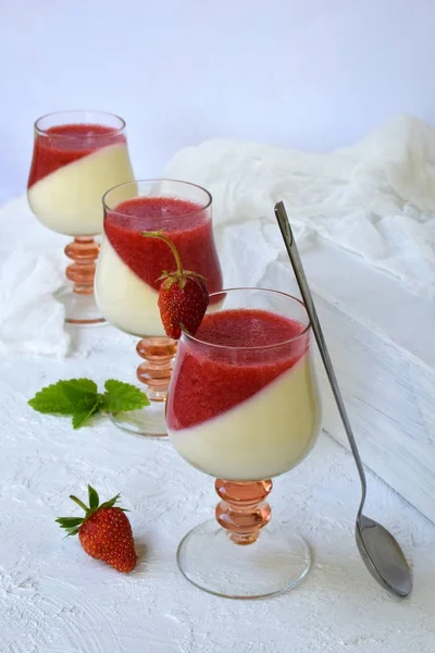 Dessert italien traditionnel panna cotta en verre avec gelée de baies. Dessert de fraise au lait vanillé en couches sur fond clair . — Photo