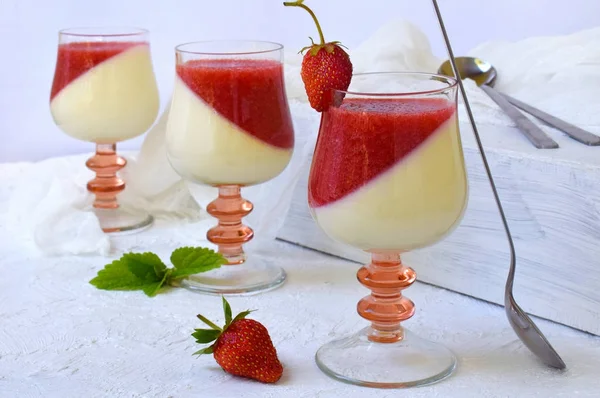 Dessert italien traditionnel panna cotta en verre avec gelée de baies. Dessert de fraise au lait vanillé en couches sur fond clair . — Photo