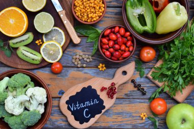 Composition of products containing ascorbic acid, vitamin C - citrus, cauliflower, broccoli, sweet pepper, kiwi, dog rose, tomatoes, apple, currant, sea buckthorn. Top view. Flat lay. clipart