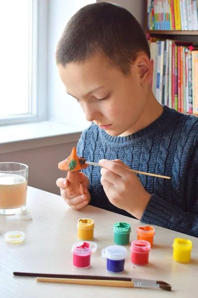 Niño haciendo juguetes de cerámica, pinta un juguete de cerámica de barro con gouache. Apoyo a la creatividad, aprendizaje por hacer, proyecto de bricolaje, artesanía. Concepto de educación y desarrollo de niños dotados . —  Fotos de Stock