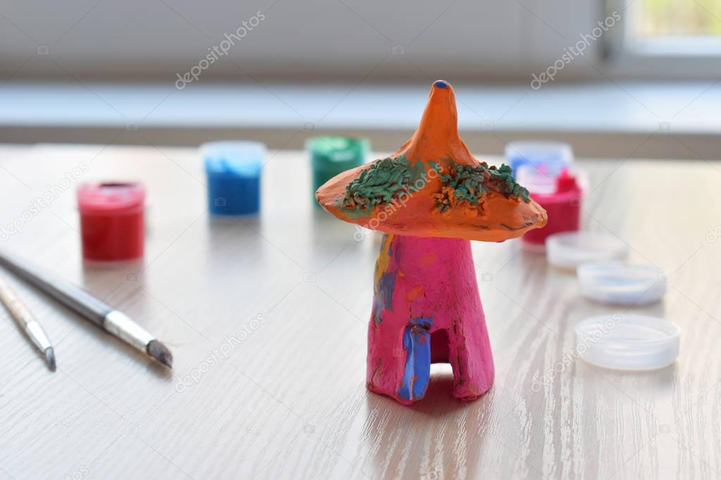 Paintbrush and handmade fairytale house from clay pottery.  Supporting creativity, learning by doing, DIY project, hand craft.  Concept of education and development of gifted children.
