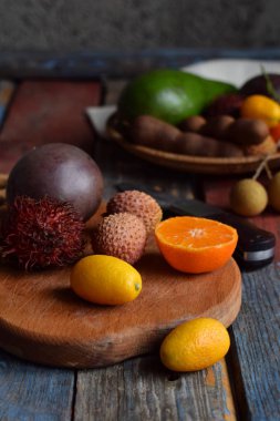Tutku meyve, Kamkat, lychee, rambutan, demirhindi, avokado, Hindistan cevizi, Ejder Gözü ahşap arka plan üzerinde olgunlaşmış tropikal meyve karışımı. Superfood arka plan. Vejetaryen yiyecekler