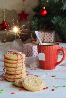 Noel ve yılbaşı tatil kutlama kavramı arka plan. Bir fincan çay, ev yapımı somun kurabiye, kurabiye, xmas ağacı süsle ahşap tablo.