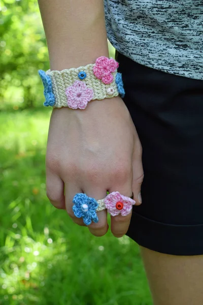 Crocheted your own jewelry. Pink and blue bracelet and ringlet on young girl. Step 3 - finished goods. DIY project. Small business. Income from hobby — Stock Photo, Image