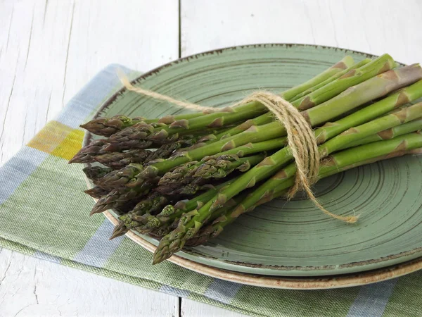 Bund frischer grüner Spargel auf hellem Holzgrund. frisches Bio-Gemüse. Erstes Frühlingsgrün. Konzept für gesunde Ernährung. Kopierraum — Stockfoto