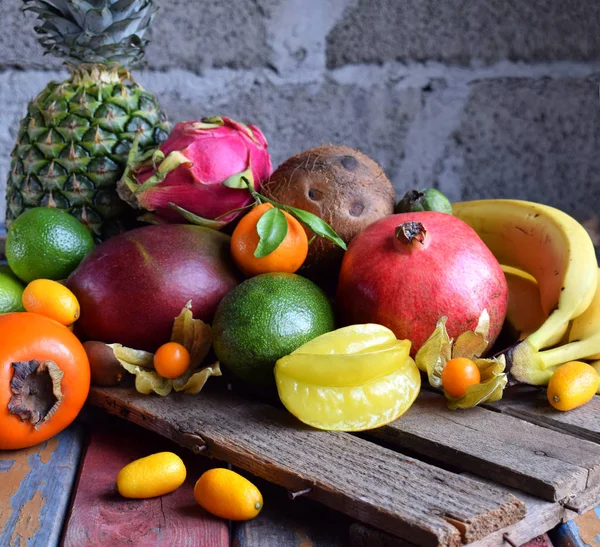 Mix of ripe tropical fruits with avocado, mango, coconut, carambola, banana, kumquat, pitahaya, kiwi. Superfood background. Vegetarian food. Copy space — Stock Photo, Image