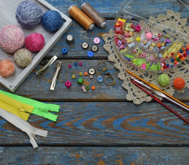 Tığ işi takı oluşturmak için dikiş aksesuarları. Boncuk, konu, kanca, ahşap arka plan üzerinde düğmeleri. Örgü, tığ işi, nakış, dikiş. Küçük işletme. Hobi geliri