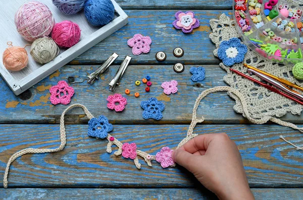 Needlework accessories for creating crocheted jewelry. Step 2 - sew crocheted flowers to bracelet or chain. DIY project. Small business. Income from hobby — Stock Photo, Image