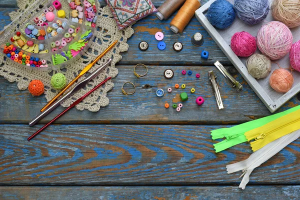 Acessórios de agulha para a criação de jóias de malha. Grânulos, fios, ganchos, botões no fundo de madeira. Tricô, crochê, bordado, costura. Pequenos negócios. Rendimento do hobby — Fotografia de Stock