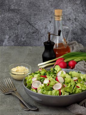 Vitamini Salata marul, turp, yeşil soğan ve yumurta, terbiyeli bitkisel yağ ve plaka gri beton zemin üzerine hardal ile. Sağlıklı gıda