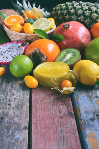 Mix of ripe tropical fruits with avocado mango, kumquat, kiwi, citrus. Superfood background. Vegetarian raw food. Copy space