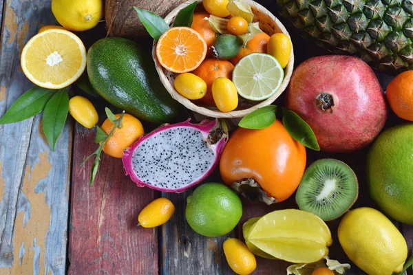 Mistura de frutas tropicais maduras com manga de abacate, kumquat, kiwi, citrinos. Antecedentes superalimentares. Comida crua vegetariana. Espaço de cópia — Fotografia de Stock