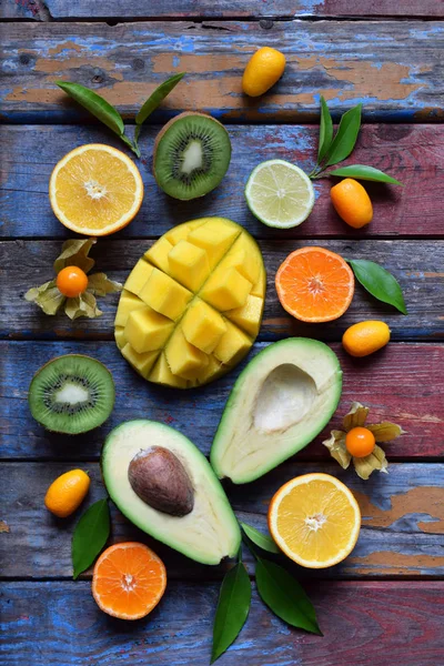 Mistura de frutas tropicais maduras com manga de abacate, kumquat, kiwi, citrinos. Antecedentes superalimentares. Comida crua vegetariana. Espaço de cópia — Fotografia de Stock