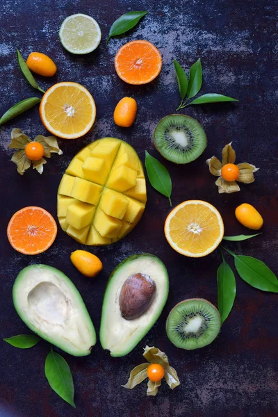 Mistura de frutas tropicais maduras com manga de abacate, kumquat, kiwi, citrinos. Antecedentes superalimentares. Comida crua vegetariana. Espaço de cópia — Fotografia de Stock