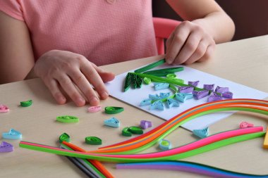 Quilling tekniği. Kız süsleme veya tebrik kartı yapmak. Kağıt şeritler, çiçek, makas. Tatil el yapımı el sanatları: doğum günü, anne veya Babalar günü, Mart 8, düğün. Çocuk DIY kavramı.