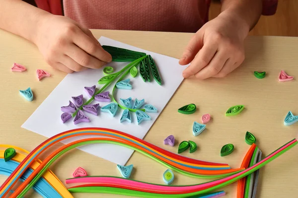 Técnica de Quilling. Chica haciendo decoraciones o tarjeta de felicitación. Tiras de papel, flores, tijeras. Artesanía artesanal en días festivos: Cumpleaños, Día de la Madre o del Padre, 8 de marzo, Boda. Concepto DIY para niños . —  Fotos de Stock