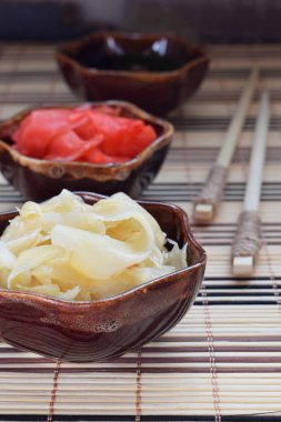 Turşu zencefil dilimleri ve ahşap yemek çubukları. Suşi için madde. Sağlıklı gıda. Geleneksel Japon çeşni.