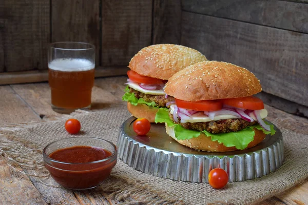 Chop patlıcan, marul, soğan turşusu, domates kahverengi ahşap arka plan üzerinde veggie burger. Vejetaryen öğle veya akşam yemeği fikir. Sağlıklı gıda.