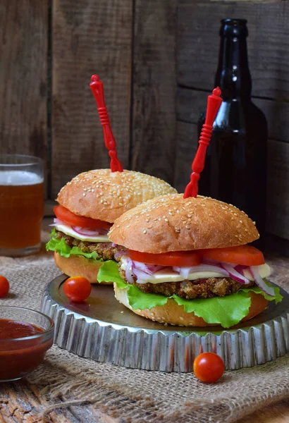 Chop patlıcan, marul, soğan turşusu, domates kahverengi ahşap arka plan üzerinde veggie burger. Vejetaryen öğle veya akşam yemeği fikir. Sağlıklı gıda.