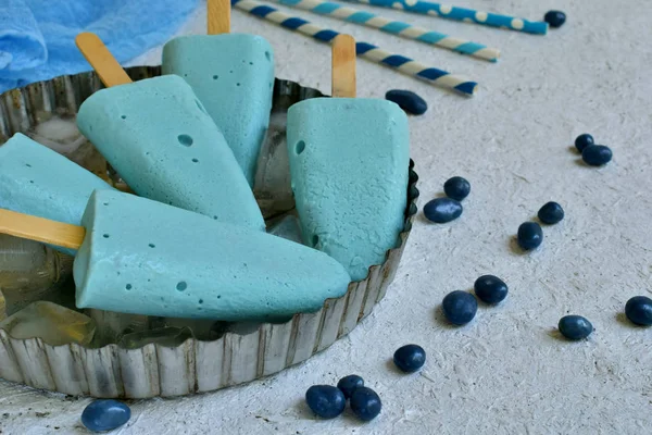 O sorvete azul aparece com frutas de mirtilo no fundo branco. Fresca sobremesa italiana turquesa refrescante. Espaço para texto — Fotografia de Stock