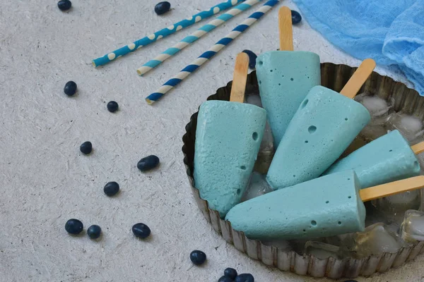 Синее мороженое с плодами черники на белом фоне. Освежающий бирюзовый итальянский десерт. Пространство для текста — стоковое фото