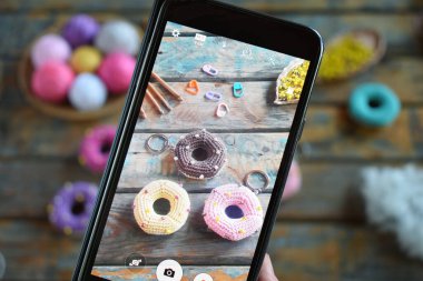 Tığ işi amigurumi çöreği yapıyorum. Bebekler için oyuncak ya da incik boncuk. Masa iplikleri, iğneler, kancalar, pamuk iplikleri. El yapımı bir hediye. Hobiden gelir. DIY el sanatları konsepti.