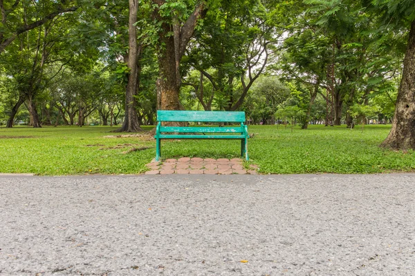 Banco del parque de madera bajo los árboles  . — Foto de Stock