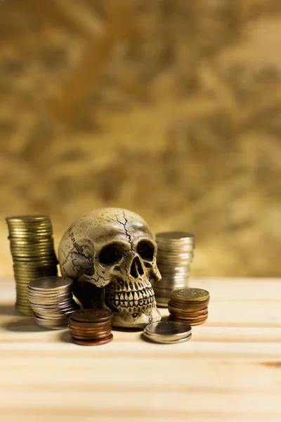 Human skull ,Pile thai coins of one bath on wood background.Conc