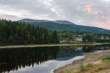 Nehir ve güneş ışığıyla kıyılarda ebedi yeşil ağaçlar, Norveç 'in en büyük kayak merkezi Trysil 