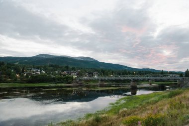 Nehir ve güneş ışığıyla kıyılarda ebedi yeşil ağaçlar, Norveç 'in en büyük kayak merkezi Trysil 