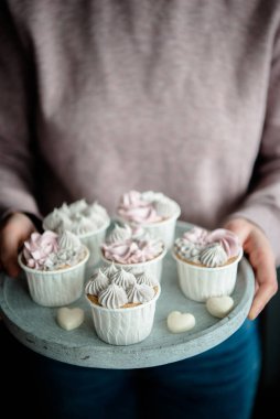 Kadın elleri lezzetli kekleri tutuyor. Krema kremalı ev yapımı vanilyalı kek. Doğum günü pastası. Sevgililer Günü tatlıları. Valente 'nin günü. Manzarayı kapat, lezzetli tatlı..