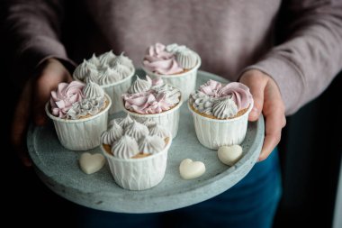 Kadın elleri lezzetli kekleri tutuyor. Krema kremalı ev yapımı vanilyalı kek. Doğum günü pastası. Sevgililer Günü tatlıları. Valente 'nin günü. Manzarayı kapat, lezzetli tatlı..