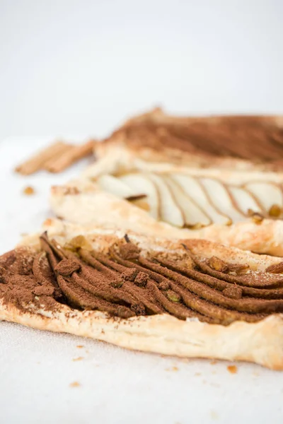 パフペーストリーパイ 梨の自家製焼きパイ 最上階だ スライスした梨とチョコレートパウダーとおいしいデザート ストック写真