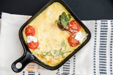 Sebzeli omlet kirazlı domates ve peynir. İtalyan kahvaltısı. Frittata. Çırpılmış yumurta. Tavada omlet pişiriyorum, yemeye hazırım.