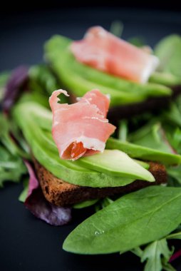 Jamonlu avokado sandviçi. Sağlıklı kahvaltı veya atıştırmalık için kızarmış ekmek, fotokopi odası. İspanyol İspanyol mezeleri. İtalyan brushetta. Vegan avokado sandviçi üst görüntüsü. Yakın plan.