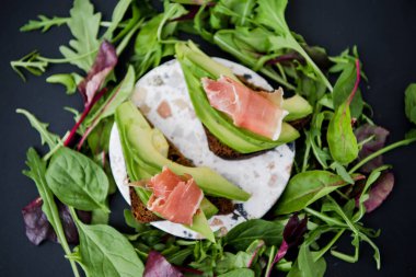 Jamonlu avokado sandviçi. Sağlıklı kahvaltı veya atıştırmalık için kızarmış ekmek, fotokopi odası. İspanyol İspanyol mezeleri. İtalyan brushetta. Vegan avokado sandviçi üst görüntüsü. Yakın plan.