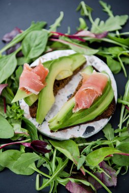Jamonlu avokado sandviçi. Sağlıklı kahvaltı veya atıştırmalık için kızarmış ekmek, fotokopi odası. İspanyol İspanyol mezeleri. İtalyan brushetta. Vegan avokado sandviçi üst görüntüsü. Yakın plan.